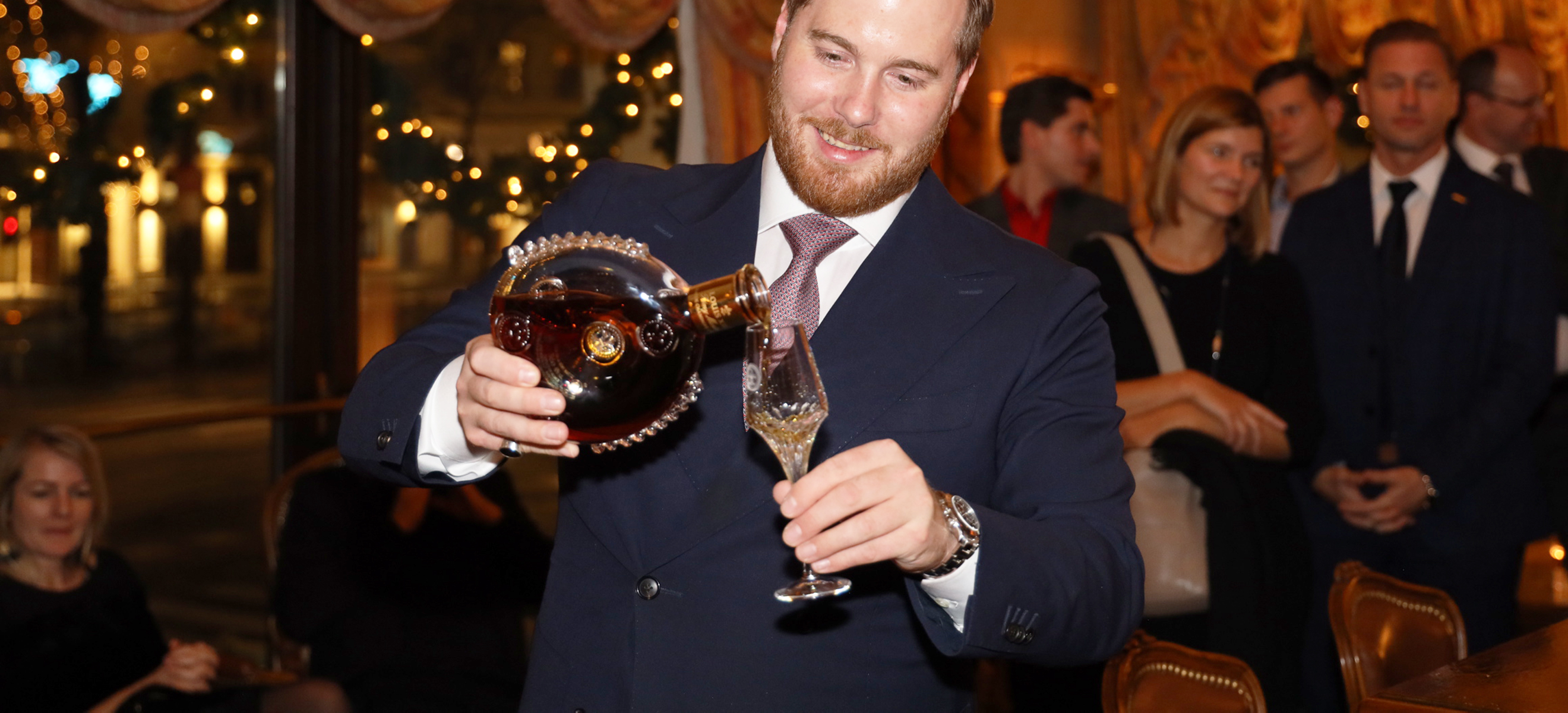 Markenbotschafter Julian Tröger schenkt ein Glas des neuen LOUIS XIII Cognacs ein.