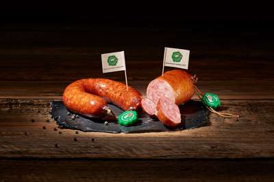 Die grüne Plombe garantiert die Herkunft der Saucissons und deren Herstellungsweise. Die hier abgebildete Saucisse aux choux beinhaltet neben Schweizer Schweinefleisch auch Kraut. 