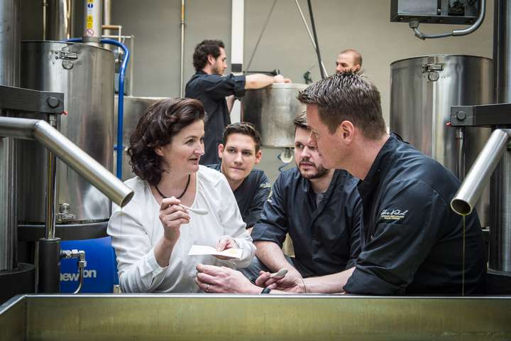 Julia Fandler zusammen mit Silvio Nickol und seinem Team in der Produktion der Ölmühle.