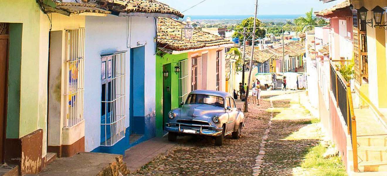 Bunte Fassaden und über Pflastersteine tuckernde Oldtimer sind typisch für Kuba.