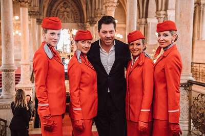 Opernsänger und Kulturmanager Daniel Serafin flankiert von attraktiven AUA-Stewardessen.
